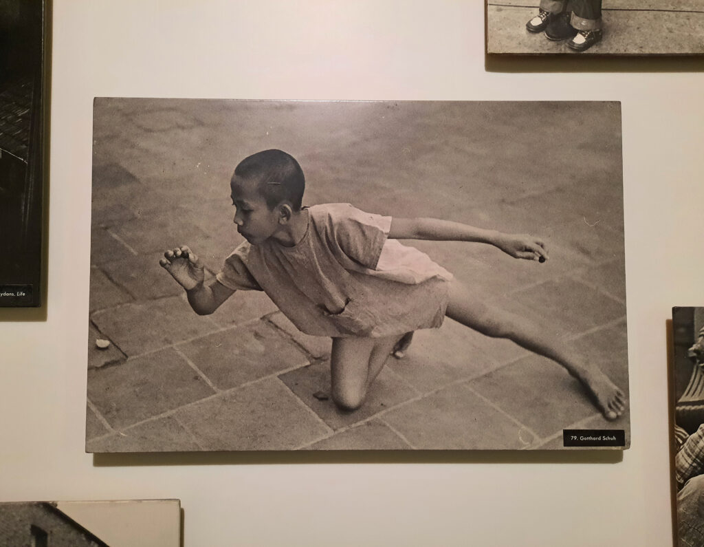 Foto «Murmelspielender Knabe aus Java» von Gotthard Schuh in der Ausstellung «The Family of Man» im Schloss Clervaux, 2023 © Stiftung Righini Fries